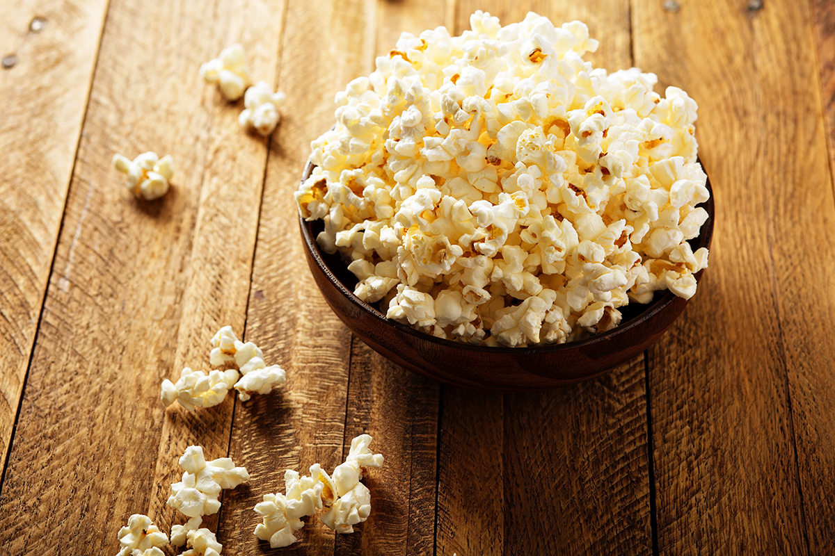 bowl-full-of-popcorn-on-a-wood-table