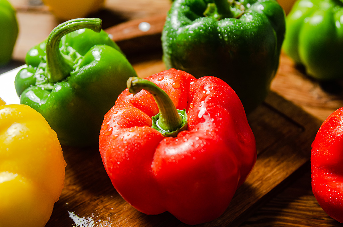 colorful-bell-peppers-with-water-droplets-on-wood colorful-bell-peppers-with-water-droplets-on-wood