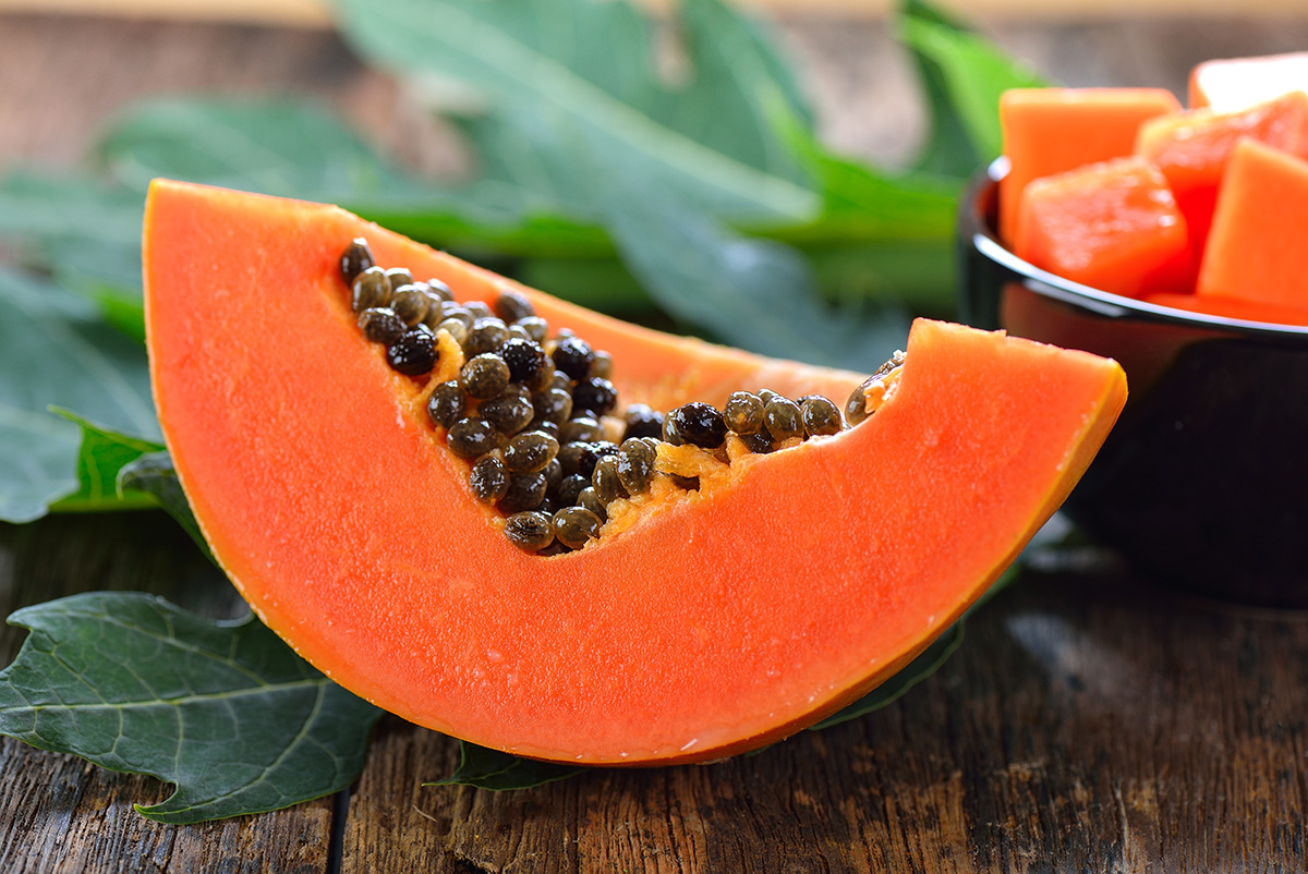 delicious-papaya-slice-with-seeds-on-wooden-surface delicious-papaya-slice-with-seeds-on-wooden-surface