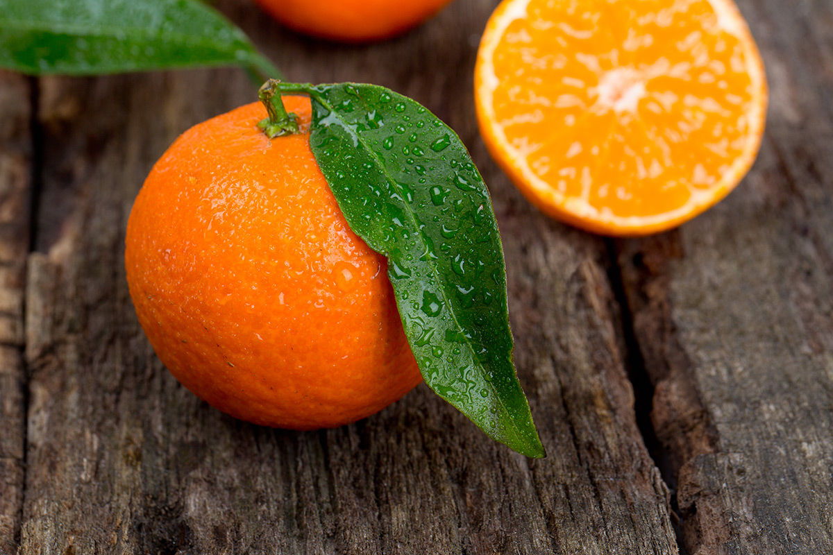 fresh-oranges-with-dew-drops-on-wooden-table